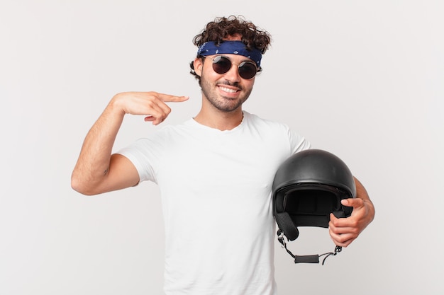 Motorbike rider smiling confidently pointing to own broad smile, positive, relaxed, satisfied attitude