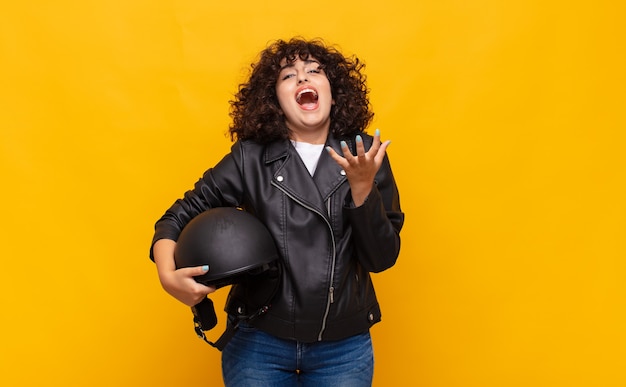 Motorbike rider woman looking desperate and frustrated, stressed, unhappy and annoyed, shouting and screaming