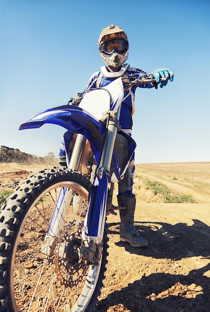 Photo motorbike sports and danger with biker person outdoor low angle with uniform for riding on dirt track speed power and risk with motorcycle transportation and adventure for adrenaline and travel