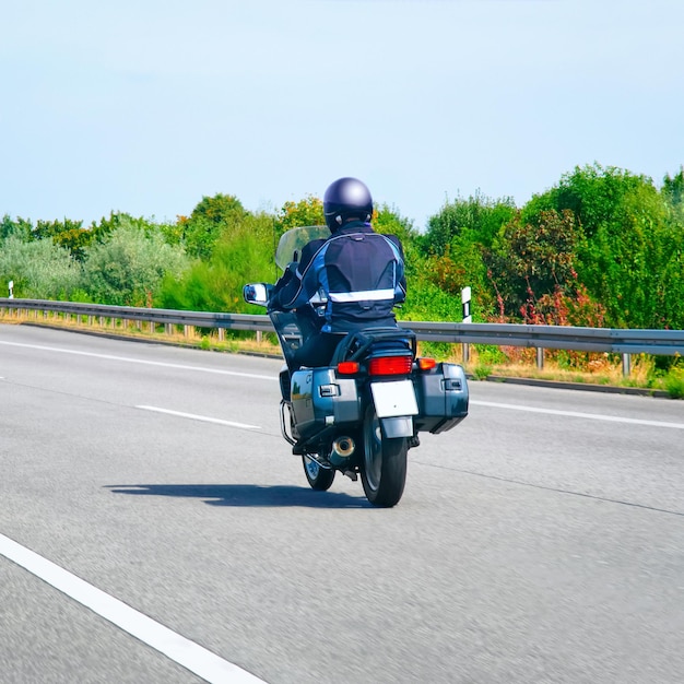 スイスの道路でバイクに乗る人。