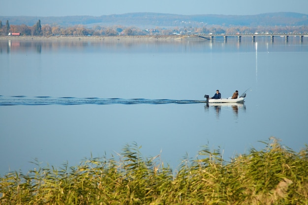 Motorboot met vissers vaart op het meerwater