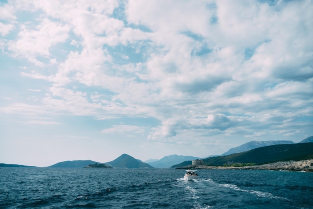 Motorboot vaart naar het mamula-eiland langs de baai van montenegro