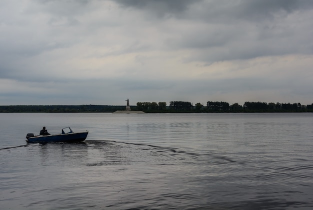 Motorboot vertrekt vanaf de kust uitzicht op het monument moeder volga rivier volga rybinsk yaroslavl ob...