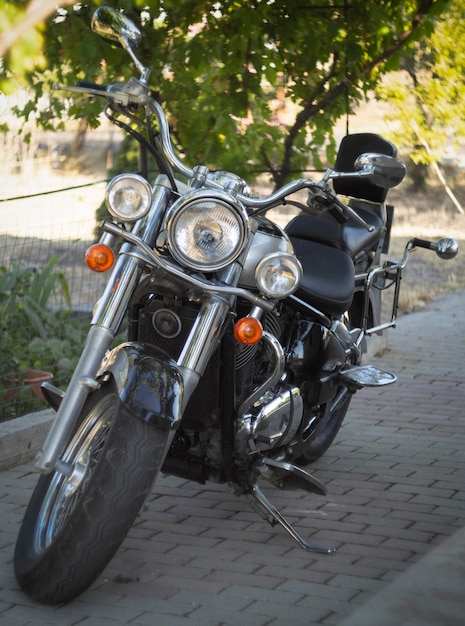 レトロなスタイルのオートバイのチョッパーは、ブドウ園の日陰に立っていますギリシャの晴れた夏