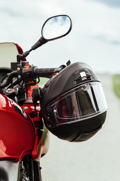 Motorcycle helmet hanging on motorcycle handle close up