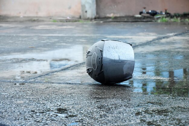 Photo motorcycle helmet for traffic lying on wet and sliping road floor accident and protection concept