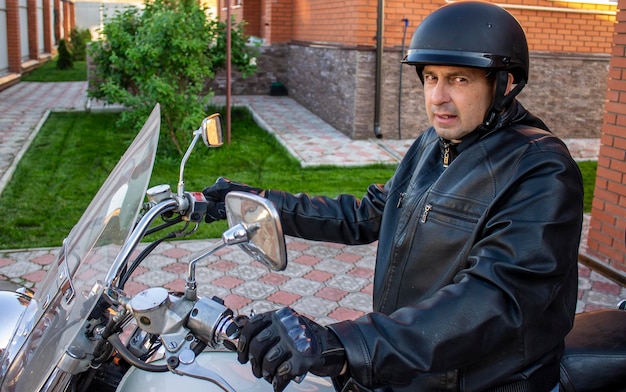 Foto uomo in motocicletta con giacca e casco