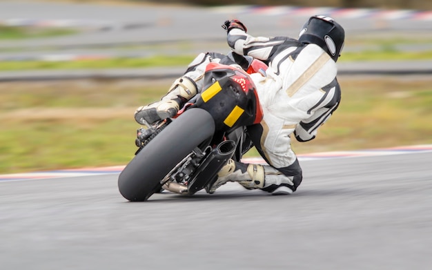 Motorcycle practice leaning into a fast corner on track