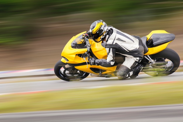 Foto pratica motociclistica appoggiata in una curva veloce in pista