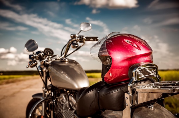 Motorcycle on the road with a helmet on the handlebars.