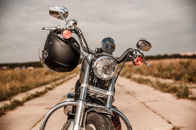 Motorcycle on the road with a helmet on the handlebars.