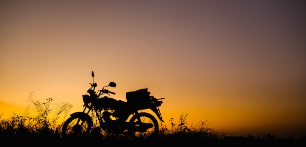 Foto motociclo nel tramonto e l'alba con copia spazio. silhouette moto