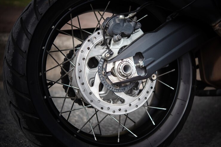 Motorcycle wheel in black and white with ABS brakes.