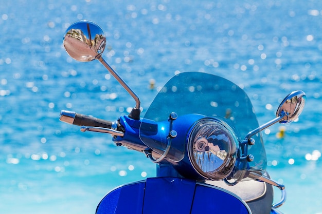 Motorcycle with chrome handles near blue water