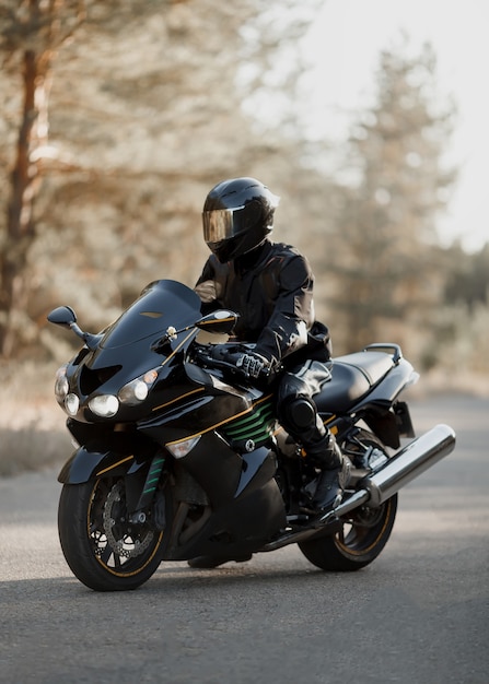 Motorcyclist in a helmet on a motorcycle on a country road.