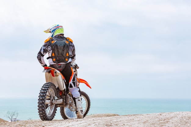 Motorcyclist in a protective suit sitting on motorbike