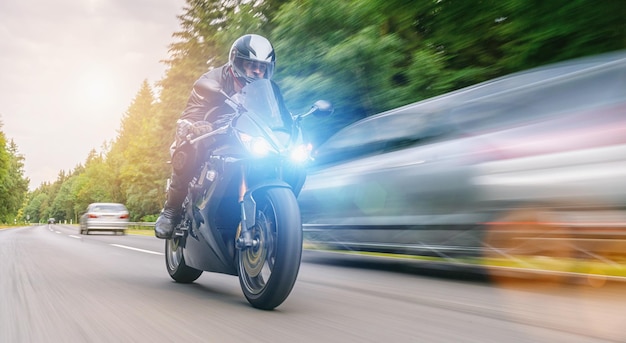 motorrijder op de bosweg rijden. plezier hebben tijdens het rijden op de lege weg tijdens een motorreis