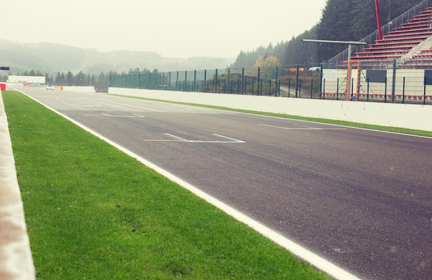 motosports, extreme and race concept - close up of speedway track or road and stands