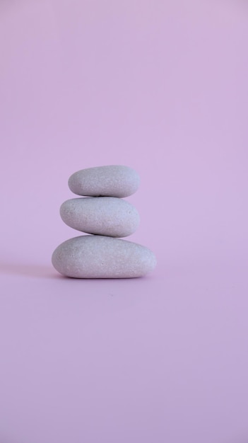 Mound of white zen stones on pink background