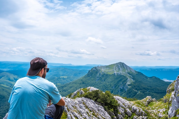 Mount Aizkorri 1523 meter, de hoogste in Guipuzcoa. Baskenland. Klim door San Adrian en keer terug door de Oltza-velden. Een jonge man in een blauw shirt kijken naar de uitzichten van bovenaf