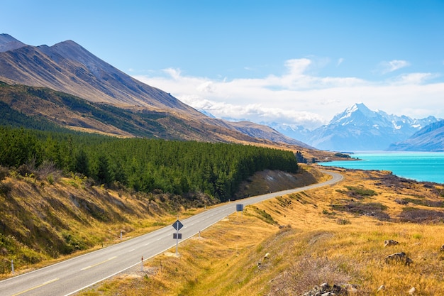 Monti il ​​punto di vista del cuoco con il pukaki del lago e la strada che conduce per montare il villaggio del cuoco nell'isola del sud nuova zelanda.