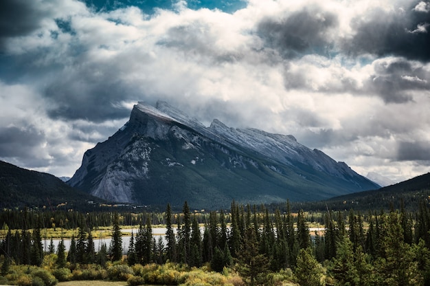 カナダのバンフ国立公園の森に劇的な雲のあるランドル山