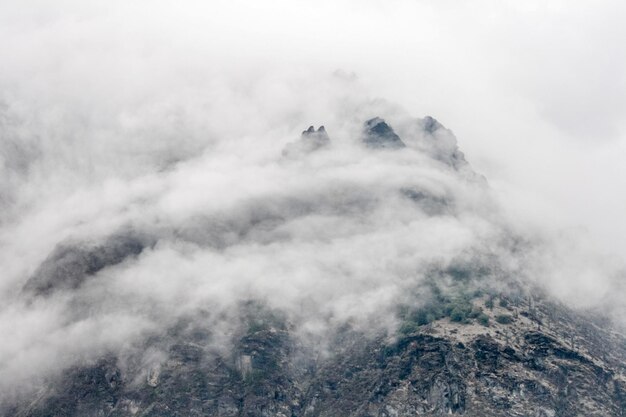 Photo mountain against sky during foggy weather