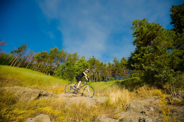 Mountain biker with a bicycle on a rock motivation and
inspiration for adventure extreme sport concept