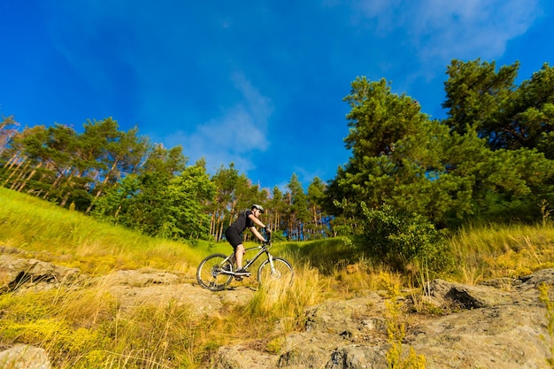 Mountain biker with a bicycle on a rock motivation and
inspiration for adventure