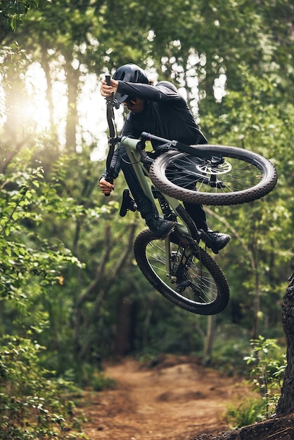 Foresta e libertà in mountain bike mentre sei in bicicletta e pedala all'aperto nella natura per allenarti, adrenalina e abilità, salute fisica e un uomo attivo in bicicletta in un'avventura all'aria aperta in norvegia