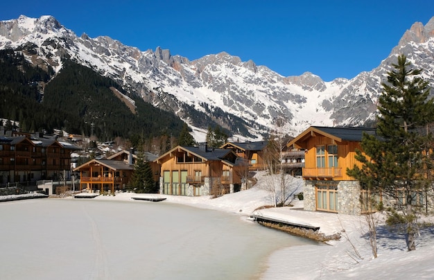 Mountain cabins next to a frozen ice lake in the winter in asutria