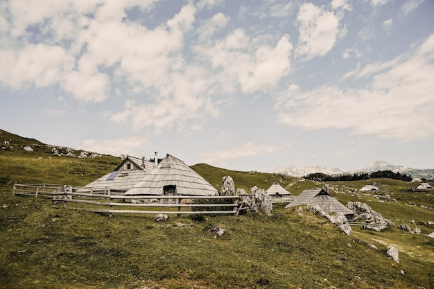 Mountain cottage hut or house on hill Velika Planina alpine meadow landscape Eco farming Travel destination for family hiking Kamnik Alps Slovenia Big Plateau