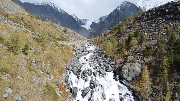 Ruscello che scorre di montagna e cascata nella foresta vista panoramica del paesaggio pittoresco dei droni aerei delle montagne dell'altai russia