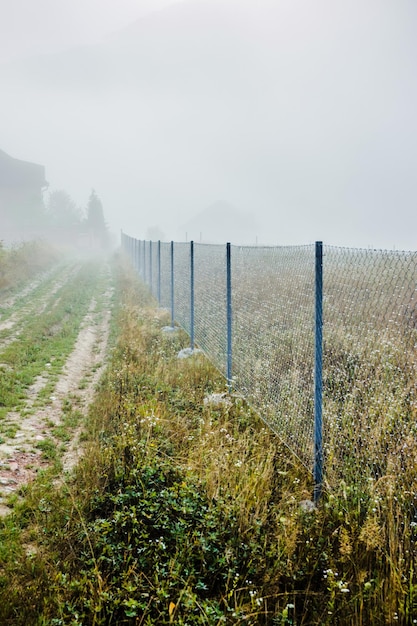 Foto montagna dalla vista con piccolo villaggio e flusso di nebbia estate nebbiosa