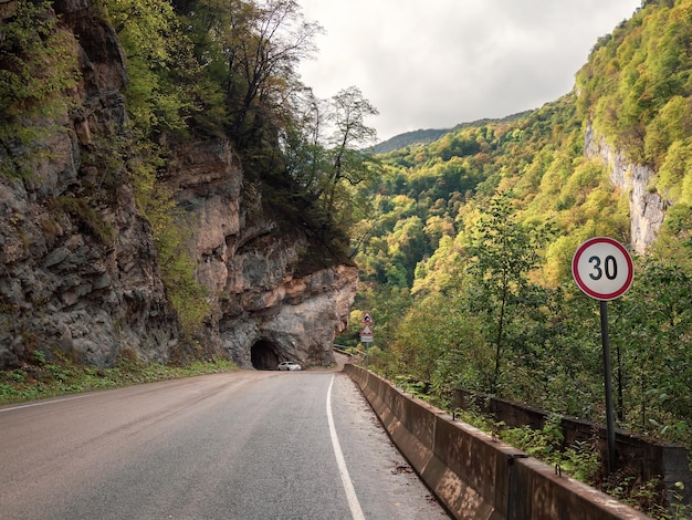 Mountain highway at the entrance to the tunnel cut into the rock Beautiful street in a rocky tunnel Caucasus mountains Digora gorge North OssetiaAlania republic