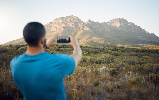 사진 야외 또는 시골에서 산악 하이킹 남자와 스마트폰 사진 온라인 소셜 미디어 좋은 기억이나 웹 게시를 위해 5g 모바일로 풍경 사진을 찍는 모험 여행과 남자