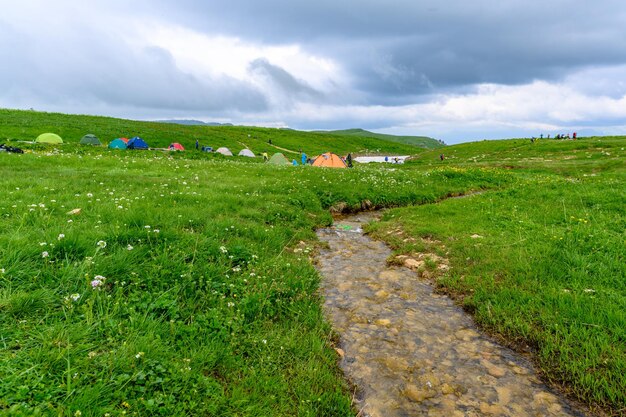 Mountain hiking trail Beautiful landscape with mountains green grass meadows and hiking trail in springtime