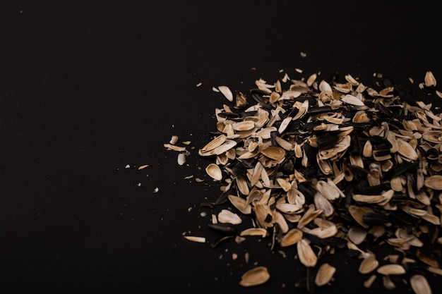 A mountain of husks from under the seeds lies on a black background