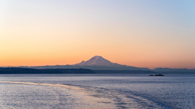 a mountain is in the background of a sunset