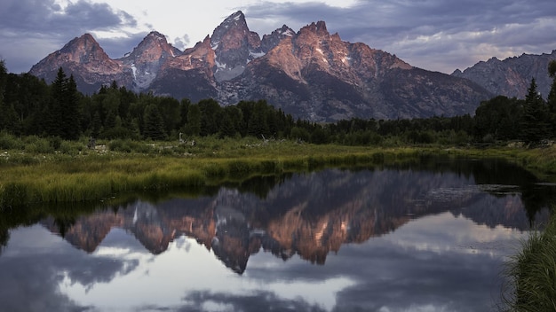 Photo a mountain is reflected in a lake with a mountain in the background