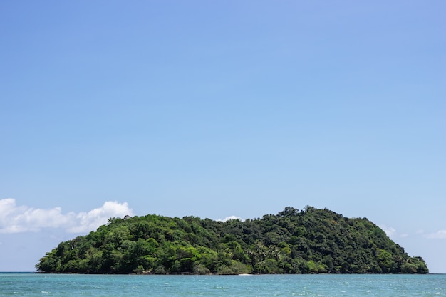 Mountain island over the sea with bright sky in background in the afternoon at Koh Mak Island in Trat, Thailand.