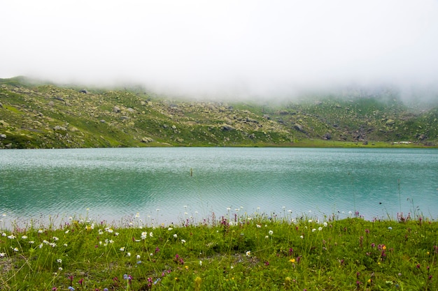 Горное озеро и туман, туманное озеро, удивительный пейзаж и вид на высокогорное озеро Охроцхали в Сванетии.