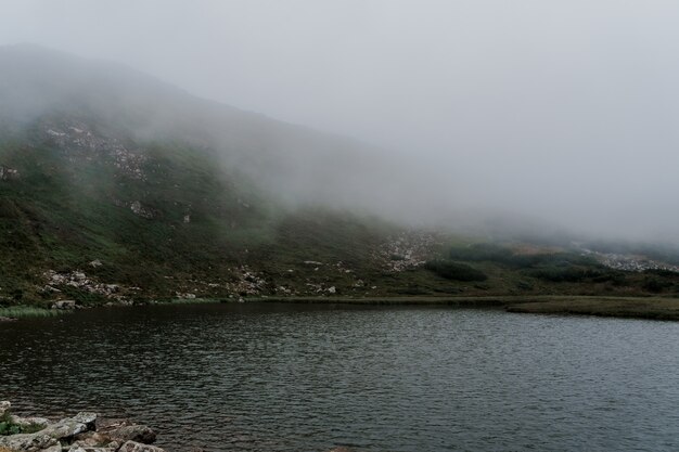 Mountain lake full of fog in rainy day