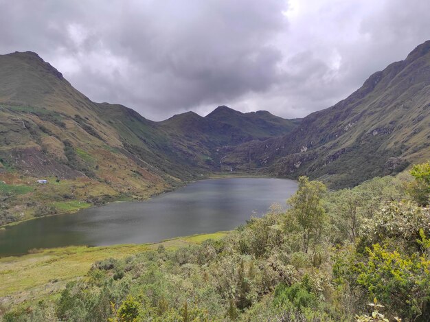 Photo a mountain lake is surrounded by mountains and the clouds are dark and cloudy laguna quero pozo