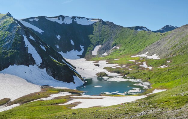 Mountain lake among snow, spring in the mountains	