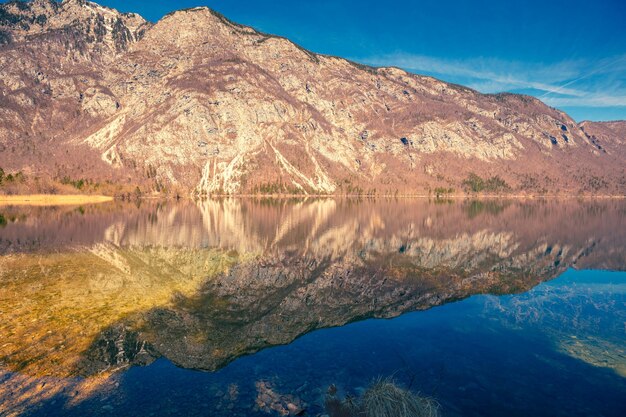 Mountain lake with beautiful reflection Lake Bohinj in early spring Triglav national park Slovenia