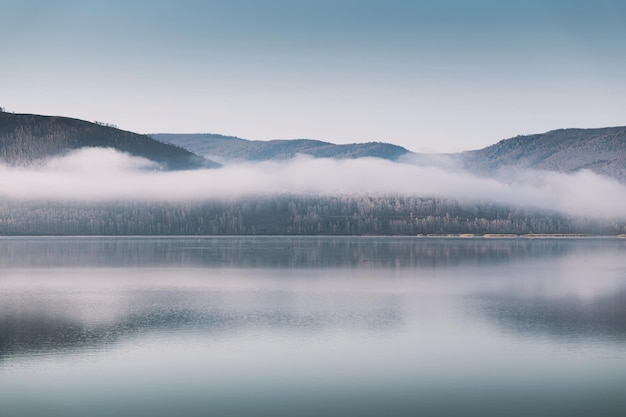 霧の朝の雲と山の湖秋の風景