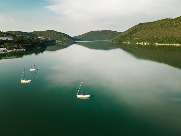 Lago di montagna con acqua turchese e yacht lago abrau nel villaggio di abraudurso in russia