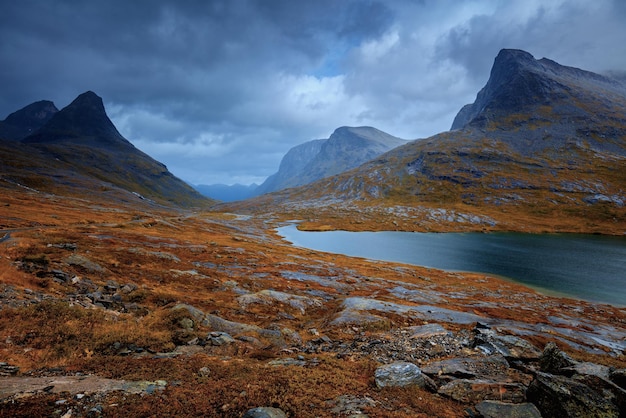 Foto paesaggio di montagna in serata riva rocciosa del lago di montagna in autunno piovoso bellissima natura norvegia