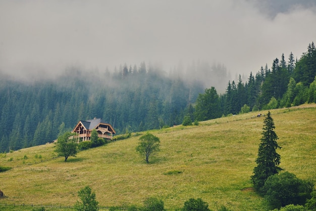 Mountain landscape in the fog house in the mountains